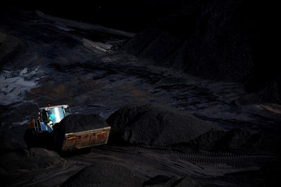 High angle view of senior man on rock at night