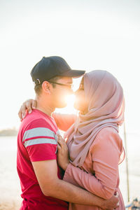 Side view of couple against sky