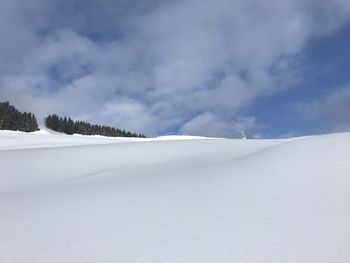 Snow covered landscape against sky