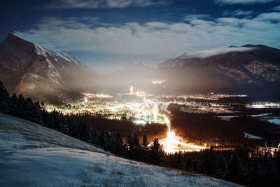 Illuminated landscape against sky at night during winter