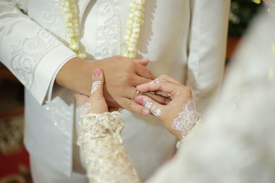 The bride puts a ring on the groom