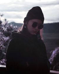 Close-up of young woman wearing sunglasses against sky
