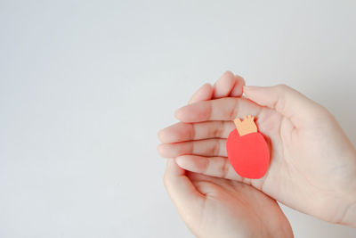 Cropped hand holding heart shape against white background