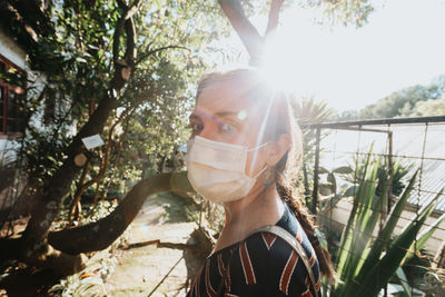 Portrait of young woman against trees