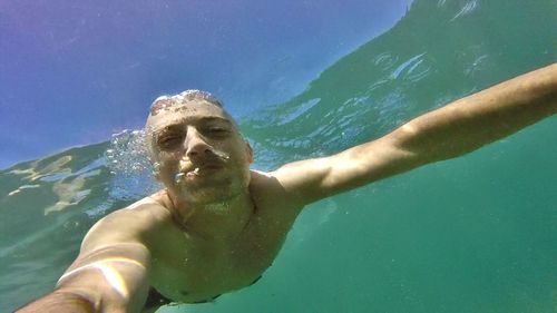 Portrait of young man swimming in sea