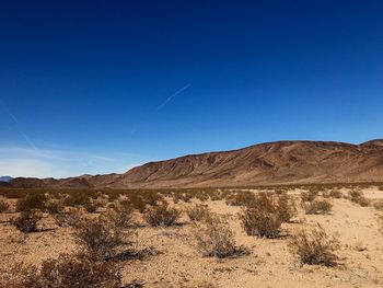 Scenic view of desert against clear blue sky