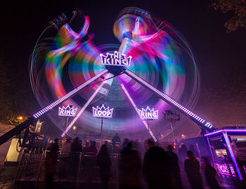 Low angle view of illuminated ferris wheel against sky at night