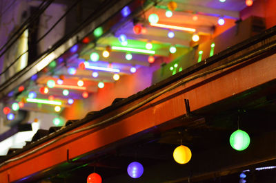 Low angle view of illuminated lights in city at night