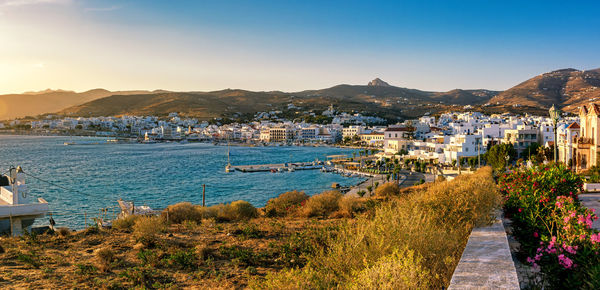 Scenic view of sea by townscape against sky
