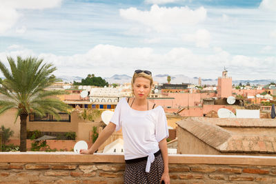 Young woman standing against cityscape