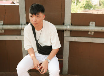 Thoughtful man sitting against wall