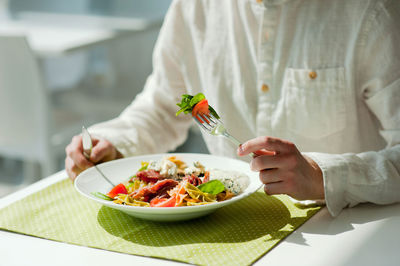 Midsection of woman holding food on table