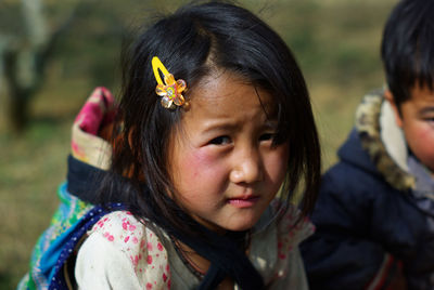 Close-up portrait of girl wearing yellow hairpin