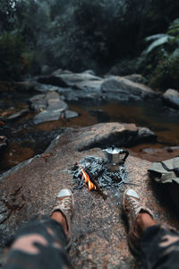 Low section of man wearing shoes on rock