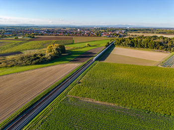 Aerial view of an ice express train between fields in the countryside