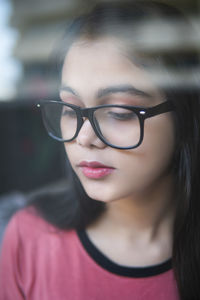 Close-up portrait of young woman wearing eyeglasses