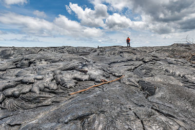 Man on rock formations against sky