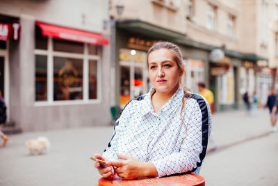 Portrait of young woman in city