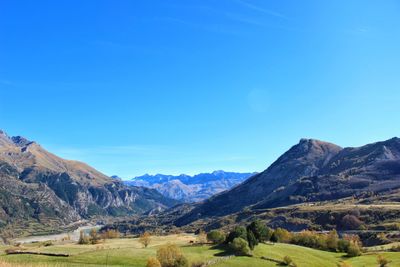 Scenic view of mountains against blue sky