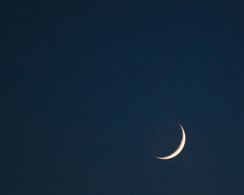 Low angle view of half moon against sky at night