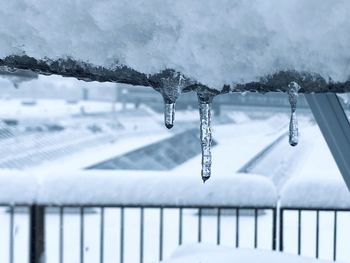Icicles on roof against snow covered landscape