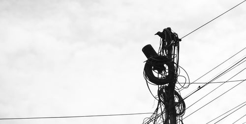 Low angle view of electricity pylon against sky