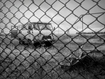 Van on field seen through chainlink fence