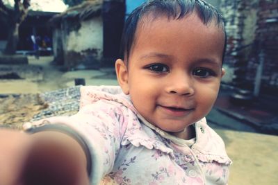 Close-up portrait of cute baby girl in village