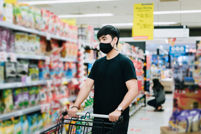 Full length of man standing against store