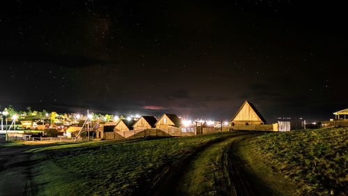 Illuminated buildings against sky at night