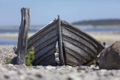 Close-up of damaged land on beach against sky