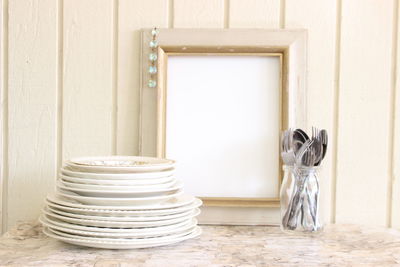 Plates and cutlery with picture frame on table