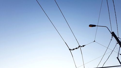 Low angle view of electricity pylon against clear sky