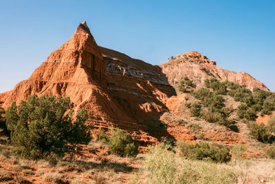 Rock formations on mountain against clear sky