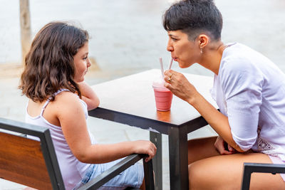 Side view of couple sitting on table