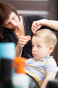 Cute boy having haircut at barber shop