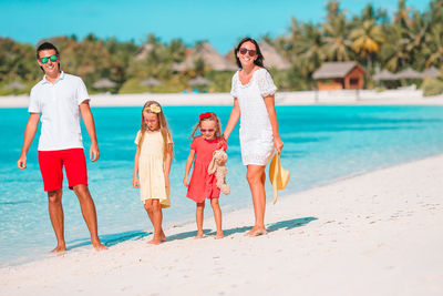 Cheerful family standing on beach