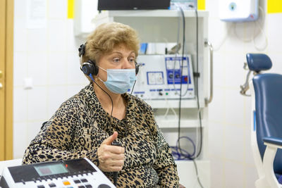 Audiologist checks the hearing of an older woman