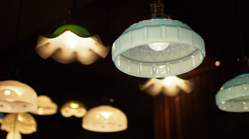 Low angle view of illuminated light bulb hanging from ceiling