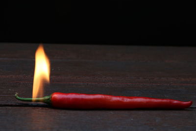 Close-up of burning candle on table