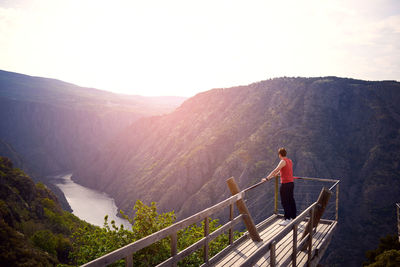 Man looking at mountains against sky