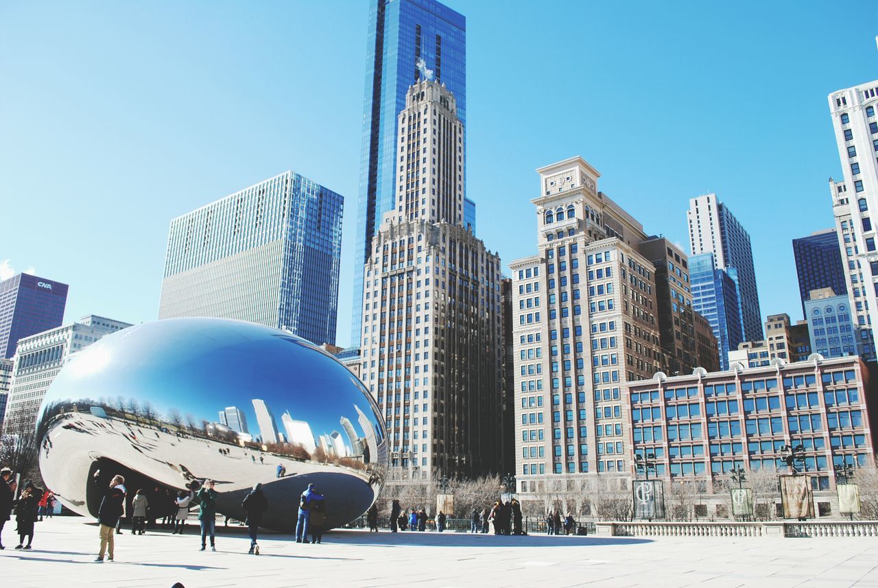 architecture, city, clear sky, building exterior, built structure, travel destinations, skyscraper, outdoors, tourism, day, low angle view, no people, sky, cityscape, modern, urban skyline, water