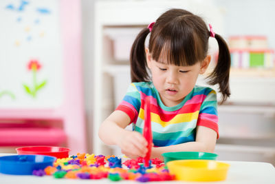 Young girl play math and color sorting fine motor skill game for homeschooling