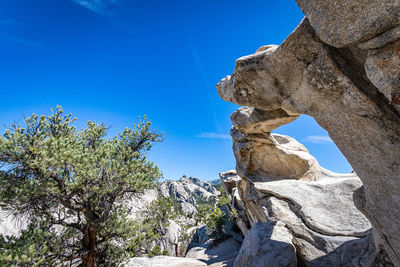 Low angle view of rock formation against clear blue sky