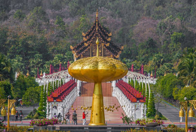 Golden gate temple against trees and building