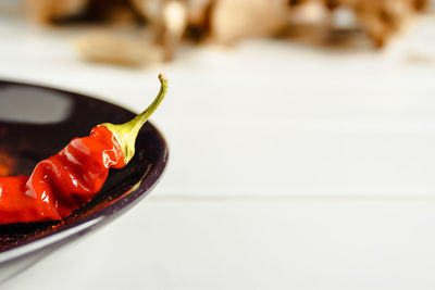 Close-up of red chili peppers in plate on table
