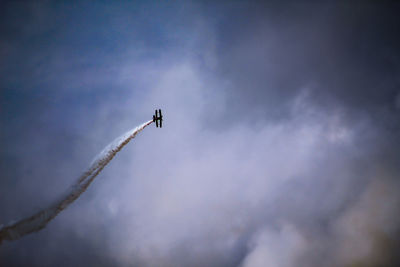 Low angle view of airplane flying against sky