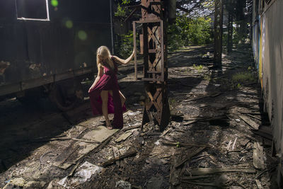 Full length of woman standing in old abandoned rusty train yard