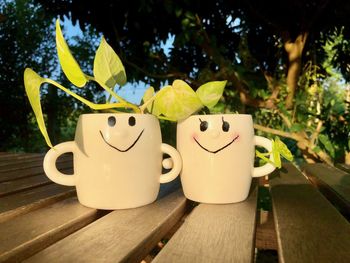 Close-up of coffee cup on table against trees