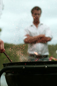 Close-up of hand preparing food on barbecue